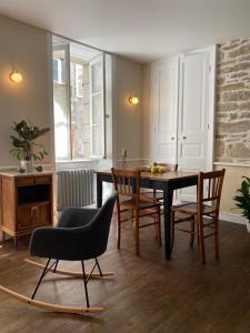 a living room with a dining room table and chairs at Les volets verts in Pont-Croix