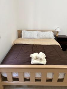 a bed with two towels sitting on top of it at Suarez home in Puerto Madryn