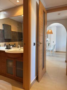 a bathroom with a sink and a mirror at SunGolf Apartment in Los Alcázares