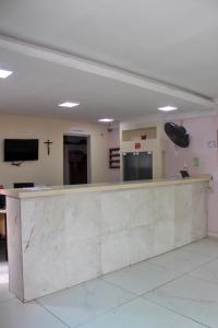a waiting room with a counter and a cross on the wall at USCEESP Praia Grande in Praia Grande +42 photos