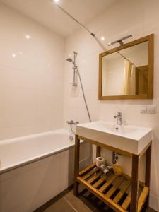 a bathroom with a sink and a bath tub at AmberHome in Liepāja