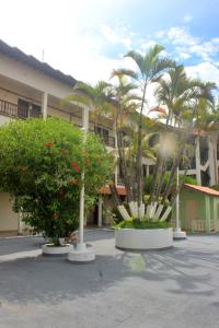 a courtyard with palm trees and a building at USCEESP Praia Grande in Praia Grande