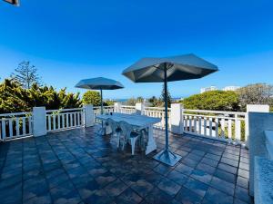 a patio with a table and an umbrella at Ameni Air B&B in Gqeberha