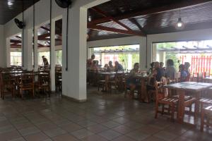 a group of people sitting at tables in a restaurant at USCEESP Praia Grande in Praia Grande