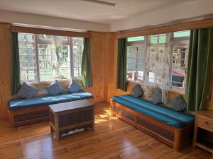 a room with two benches in a room with windows at Paljor Farm in Ravangla