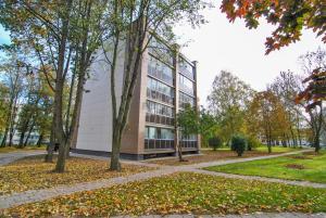 un grand bâtiment avec des arbres devant lui dans l'établissement Luxury apartment, à Druskininkai
