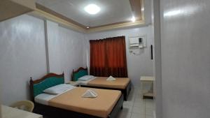 a small room with two beds and a window at Paper Country Inn in Mangagoy +25 photos