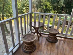 a table and two stools sitting on a porch at Paljor Farm in Ravangla +7 photos