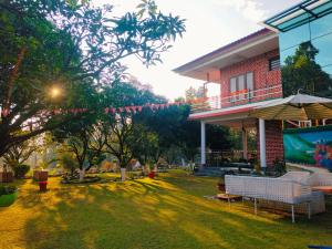 a house with a yard with benches and trees at Vida Homestay in Nakraunda