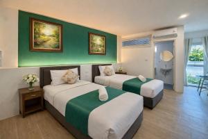 two beds in a hotel room with green walls at KYP Hotel โรงแรมขุนยูวเพลส in Fang +54 photos