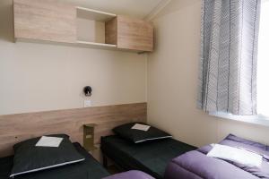 a room with two beds and a window at Camping Pomme de Pin in Stella-Plage