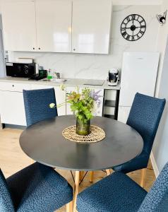 un tavolo con un vaso di fiori sopra in una cucina di Apartmán VeVa - 2kk blízko centra, balkon, parkování, Wi-Fi a Znojmo