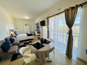 a living room with a bed and a table in a room at Ameni Air B&B in Gqeberha