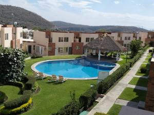 a pool in a yard with chairs and a gazebo at Hermosa casa familiar con terraza comoda in Xochitepec
