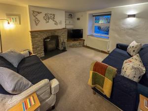 a living room with two couches and a fireplace at Arcadia Cottage, Mere in Mere
