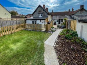 a backyard with a wooden fence and a yard at Arcadia Cottage, Mere in Mere