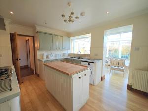 a kitchen with white cabinets and a wooden floor at 2 Bed in Brighstone oc-n30464 in Brighstone +8 photos