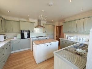 a large kitchen with white cabinets and white appliances at 2 Bed in Brighstone oc-n30464 in Brighstone