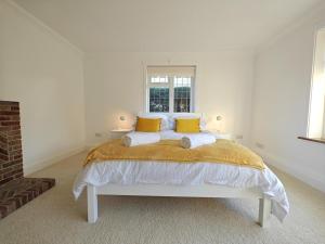 a white bedroom with a large bed with yellow pillows at 2 Bed in Brighstone oc-n30464 in Brighstone