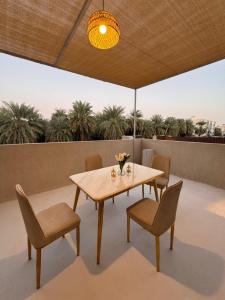 a table and chairs on a balcony with palm trees at شقة وقف الخير اسبوعي وشهري Charity apartment, weekly and monthly in Medina +60 photos