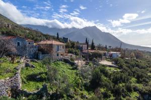 a village on a hill with a mountain in the background at Stone house koumani in Thalámai