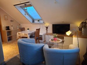 a living room with two blue chairs and a tv at Privatvermietung Giese in Kiel