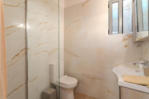 a bathroom with a toilet and a glass shower at Stone house koumani in Thalámai +19 photos