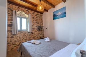 a bedroom with a bed with towels on it at Stone house koumani in Thalámai