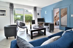 a blue living room with a blue couch and chairs at Spacieuse maison avec piscine proche plage à Canca in Cancale