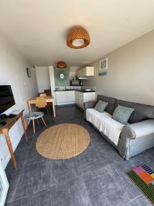 a living room with a couch and a kitchen at Villa Denise Petit Gîte in Barneville-Carteret
