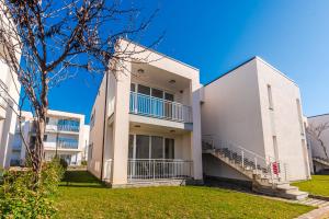 a large white building with a grass yard at Blue Haven Talea by PikHost in Tale