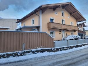 a house with a fence in the snow at Ferienwohnung-Gerti in Uderns