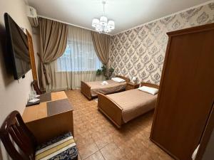 a hotel room with two beds and a television at Dvoryanskiy Hotel in Dnipro