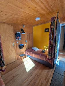 a bedroom with a bed in a wooden room at Chambre d'hôtes Chalet AILLEURS in Molines-en-Queyras