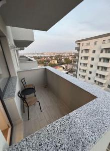 ein Stuhl, der auf dem Balkon eines Gebäudes steht in der Unterkunft Studio Ajustorului rezidence ,Lacu Morii in Bukarest