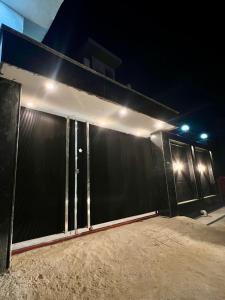 a black garage door with lights on it at night at Nirmal sadan Homestay in Barsāna