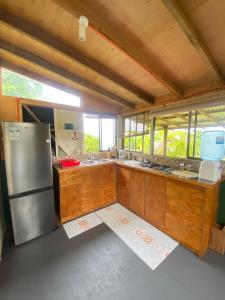 a kitchen with wooden cabinets and a stainless steel refrigerator at Studio Sunset Rapa Nui in Hanga Roa