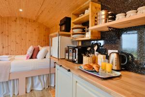 a kitchen with a bed and a counter with a tray of food at Finest Retreats - Demelza Shepherds Hut in Grade