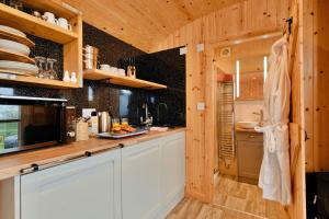 a kitchen with white cabinets and wooden walls at Finest Retreats - Demelza Shepherds Hut in Grade +4 photos