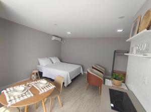a bedroom with a bed and a table with a dining room at Refúgio leve no Campeche in Florianópolis