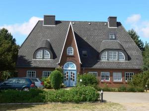 a house with a gambrel roof with a blue door at Viktor-Jaeger-Stiftung in Nebel