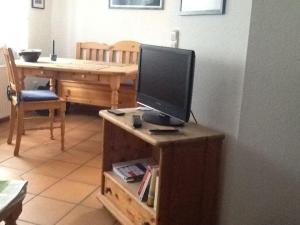 a computer monitor on a wooden stand with a table at Viktor-Jaeger-Stiftung in Nebel