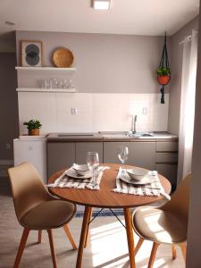 a kitchen with a wooden table with two wine glasses at Refúgio leve no Campeche in Florianópolis