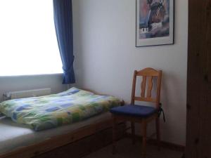 a bed and a chair in a room with a window at Viktor-Jaeger-Stiftung in Nebel