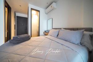 a bedroom with a large bed with pillows on it at Luxury Edge Seaview Apartment in Pattaya South