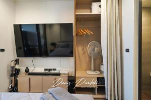 a bedroom with a tv and a bed with a fan at Luxury Edge Seaview Apartment in Pattaya South