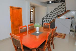 a dining room table with chairs and a vase on it at Dream Stay Green in Nuwara Eliya