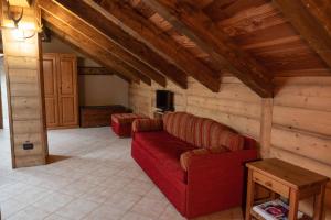 a living room with a red couch and a table at Chalet Della Guida in Bardonecchia