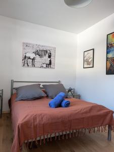 a bedroom with a bed with two blue pillows on it at Ailleurs La Chalp à Saint-Véran in Saint-Véran
