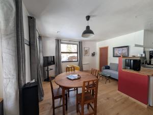 a kitchen and living room with a table and chairs at Ailleurs La Chalp à Saint-Véran in Saint-Véran